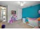 Vibrant bedroom with bright blue accent wall, fun decor, and comfortable carpeting at 7927 Hampton Lake Dr, Tampa, FL 33647