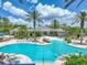 Grand Hampton community pool featuring a lagoon style pool with lounge chairs and palm trees at 7927 Hampton Lake Dr, Tampa, FL 33647