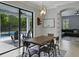 Bright dining area featuring a rustic table, modern light fixture, and sliding glass doors to the outdoor pool area at 7927 Hampton Lake Dr, Tampa, FL 33647