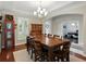 Formal dining room featuring a large table, elegant chandelier, and natural light from the nearby window at 7927 Hampton Lake Dr, Tampa, FL 33647