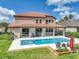 Beautiful exterior showcasing the backyard pool, spa, covered patio, and well-manicured lawn at 7927 Hampton Lake Dr, Tampa, FL 33647