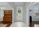Bright foyer featuring a glass-paneled door, tile flooring, and a decorative hutch at 7927 Hampton Lake Dr, Tampa, FL 33647