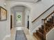 Inviting foyer with tiled floors, staircase, and arched doorway at 7927 Hampton Lake Dr, Tampa, FL 33647