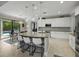 Open kitchen with large island, stainless steel appliances, granite counters, and view to the outdoor pool at 7927 Hampton Lake Dr, Tampa, FL 33647