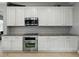 Clean kitchen featuring white cabinets, stainless steel appliances, and stylish backsplash at 7927 Hampton Lake Dr, Tampa, FL 33647