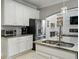 Modern kitchen with granite countertops, stainless steel appliances, and sleek white cabinets at 7927 Hampton Lake Dr, Tampa, FL 33647