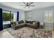 Cozy living room featuring a plush sectional sofa, ceiling fan, and view of the outdoor pool area at 7927 Hampton Lake Dr, Tampa, FL 33647