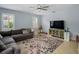 Comfortable living room with a gray sofa, ceiling fan, large TV, and ample space for relaxation and entertainment at 7927 Hampton Lake Dr, Tampa, FL 33647