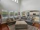 Bright living room featuring high ceilings, hardwood floors, and a comfortable grey sectional sofa at 7927 Hampton Lake Dr, Tampa, FL 33647
