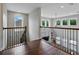 Open loft area with wood floors, stylish railings, and ample natural light, ideal for versatile use at 7927 Hampton Lake Dr, Tampa, FL 33647