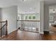 Open loft area featuring hardwood floors, decorative iron railings, and views of the downstairs living spaces at 7927 Hampton Lake Dr, Tampa, FL 33647
