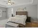 Spacious main bedroom featuring a tufted headboard, tray ceiling, and neutral color palette at 7927 Hampton Lake Dr, Tampa, FL 33647