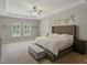 Bright and airy main bedroom with a tufted headboard, tray ceiling, and ample natural light at 7927 Hampton Lake Dr, Tampa, FL 33647