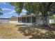 Backyard features a screened patio and a large mature shade tree at 8733 Goshen Ln, Port Richey, FL 34668