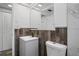 Bathroom featuring a vanity, marble tile, wood accent, white toilet, and lighting at 8733 Goshen Ln, Port Richey, FL 34668