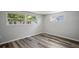 Bedroom with windows, wide plank flooring, neutral color palette, baseboards, and electrical outlets at 8733 Goshen Ln, Port Richey, FL 34668