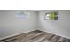 Bedroom with two windows, wide plank flooring, neutral color palette, and baseboards at 8733 Goshen Ln, Port Richey, FL 34668