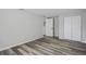 This bedroom has wood-look flooring, a closet, and a white door at 8733 Goshen Ln, Port Richey, FL 34668