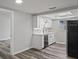 Corner view of the kitchen with white cabinets, quartz countertops, stainless steel appliances, and gray flooring at 8733 Goshen Ln, Port Richey, FL 34668