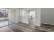Open living room with wide plank floors that flows to the kitchen with white cabinets at 8733 Goshen Ln, Port Richey, FL 34668