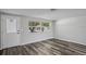Bright living room with new wood-look floors and a decorative front door at 8733 Goshen Ln, Port Richey, FL 34668