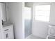 A bright bathroom has a glass shower, a window, a vanity and a toilet at 8817 Audrey Ln, Tampa, FL 33615