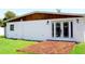 View of the home's back exterior featuring a wooden deck and white siding with wood trim above at 8817 Audrey Ln, Tampa, FL 33615