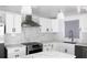 Modern kitchen with white cabinets, stainless steel appliances, marble backsplash and an island with countertop seating at 8817 Audrey Ln, Tampa, FL 33615