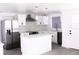 Modern kitchen with white cabinets, stainless steel appliances, marble backsplash and an island with countertop seating at 8817 Audrey Ln, Tampa, FL 33615