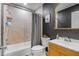 Bathroom featuring a tub with shower, a vanity and black accent wall at 9653 Golden Grove St, Seminole, FL 33772