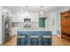 Modern kitchen featuring white cabinets, stainless steel appliances, a stylish island with seating, and a striking barn door at 9653 Golden Grove St, Seminole, FL 33772