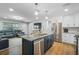 Open-concept kitchen featuring a large island with seating, stainless steel appliances, and seamless flow into the living area at 9653 Golden Grove St, Seminole, FL 33772