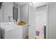 Organized laundry room with a washer, dryer, and storage, leading to the bathroom at 9653 Golden Grove St, Seminole, FL 33772