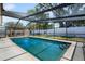 Inviting screened-in pool area with a pergola and well-maintained landscaping at 9653 Golden Grove St, Seminole, FL 33772