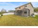 Backyard with a screened-in patio and a well-maintained lawn and white vinyl fence at 10525 Lucaya Dr, Tampa, FL 33647