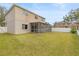 Backyard with a screened-in patio and a well-maintained lawn and white vinyl fence at 10525 Lucaya Dr, Tampa, FL 33647