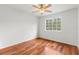 Bright bedroom features rich hardwood floors and a ceiling fan, illuminated by natural light from a large window at 10525 Lucaya Dr, Tampa, FL 33647