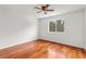 Bright bedroom features rich hardwood floors and a ceiling fan, illuminated by natural light from a large window at 10525 Lucaya Dr, Tampa, FL 33647