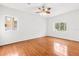 Bright bedroom with hardwood floors, two windows, and a ceiling fan at 10525 Lucaya Dr, Tampa, FL 33647