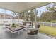 A screened patio with comfortable seating and a view of the backyard at 10525 Lucaya Dr, Tampa, FL 33647