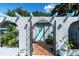 Charming front entrance with an arched pergola, gate, and a light blue front door at 10907 Kewanee Dr, Temple Terrace, FL 33617
