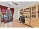 Well-lit home office with wooden desk, shelving, and French doors leading to the outside at 10907 Kewanee Dr, Temple Terrace, FL 33617