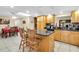 Open kitchen with breakfast bar, wooden cabinetry, and adjacent dining area at 10907 Kewanee Dr, Temple Terrace, FL 33617