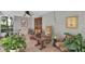 Relaxing patio features a variety of potted plants, rocking chair, and tiled flooring, perfect for enjoying the outdoors at 10907 Kewanee Dr, Temple Terrace, FL 33617