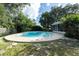 Inviting in-ground pool surrounded by mature trees and an enclosed patio provides a relaxing outdoor experience at 10907 Kewanee Dr, Temple Terrace, FL 33617