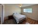 Cozy bedroom featuring hardwood floors, a ceiling fan, and ample natural light from a window at 11485 Oakhurst Rd # 319, Largo, FL 33774
