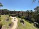 View of the building with manicured lawns, sidewalks, and seating areas in the courtyard at 11485 Oakhurst Rd # 319, Largo, FL 33774