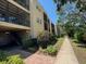 A view shows the buildings exterior with landscaping near a sidewalk and the stairs at 11485 Oakhurst Rd # 319, Largo, FL 33774