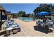 Community pool area with lounge chairs, tables, umbrellas, and a lush, landscaped surrounding providing a relaxing atmosphere at 11485 Oakhurst Rd # 319, Largo, FL 33774