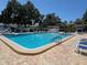 Expansive community pool surrounded by brick pavers and lounge chairs, providing a relaxing outdoor space at 11485 Oakhurst Rd # 319, Largo, FL 33774